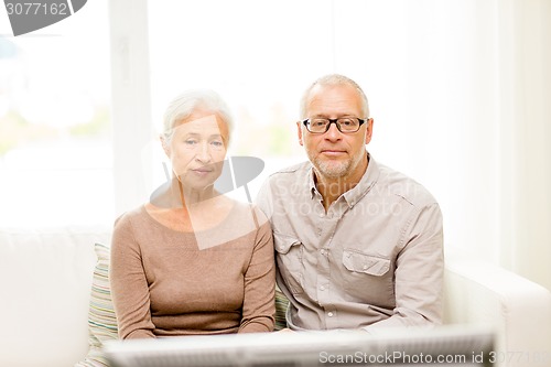 Image of senior couple watching tv at home