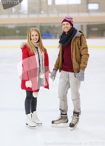 Image of happy couple holding hands on skating rink