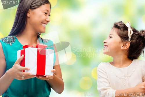 Image of happy mother and daughter with gift box