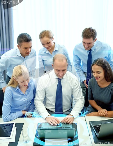 Image of smiling business people with laptop in office