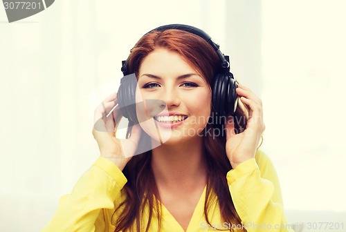 Image of smiling young girl in headphones at home