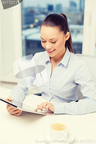 Image of smiling businesswoman with tablet pc in office