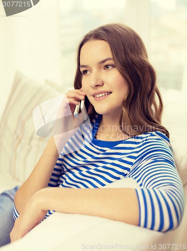 Image of smiling teenage girl with smartphone at home