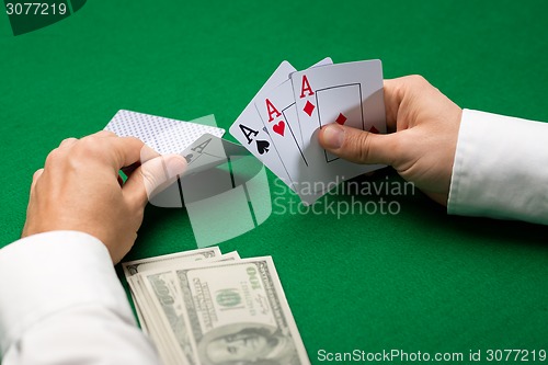 Image of poker player with cards and money at casino