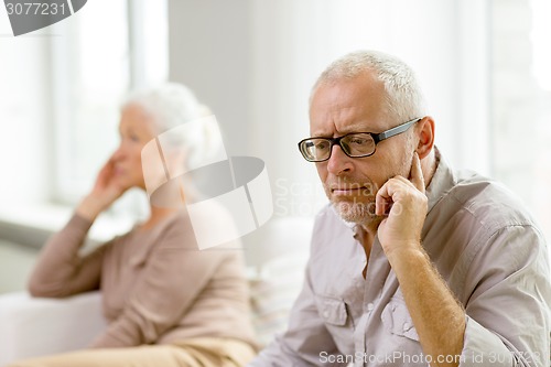 Image of senior couple sitting on sofa at home