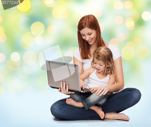 Image of happy mother with adorable little girl and laptop