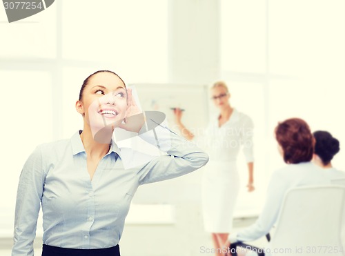 Image of smiling businesswoman listening gossig