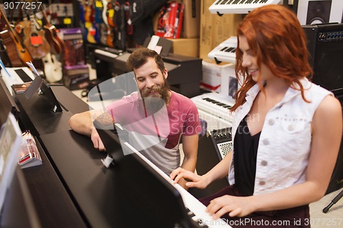 Image of man and woman playing piano at music store