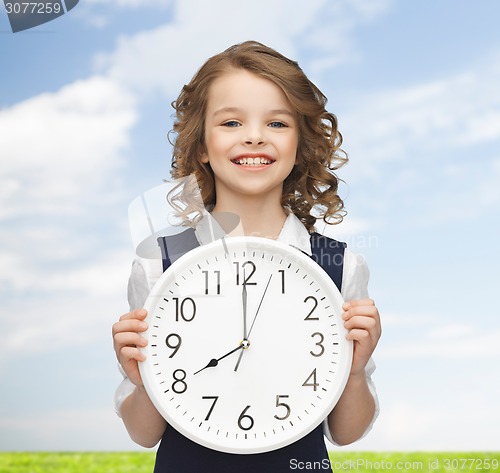 Image of smiling girl holding big clock