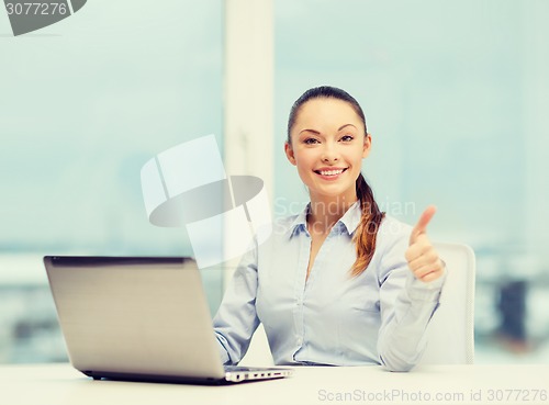 Image of businesswoman with laptop in office