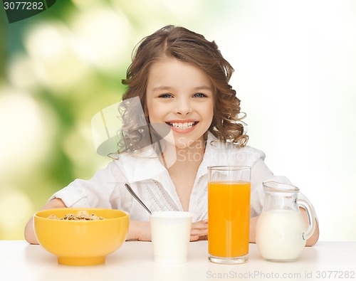 Image of happy girl eating healthy breakfast