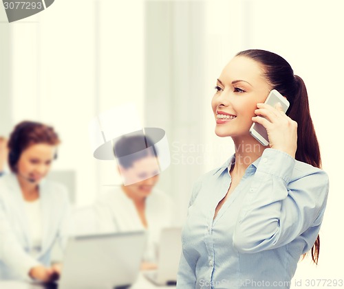 Image of young smiling businesswoman with smartphone