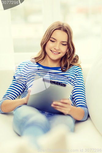 Image of smiling teenage girl with tablet pc at home