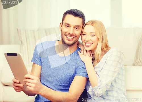 Image of smiling happy couple with tablet pc at home