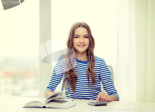 Image of student girl with book, calculator and notebook