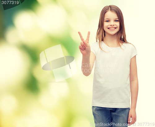 Image of little girl in white t-shirt showing peace gesture