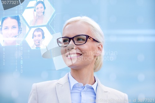 Image of young smiling businesswoman in eyeglasses outdoors