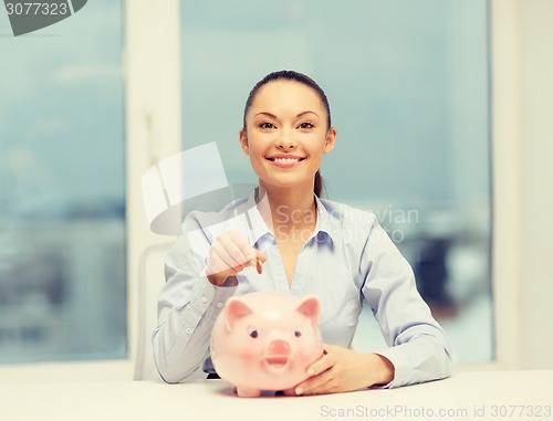 Image of smiling woman with piggy bank and cash money