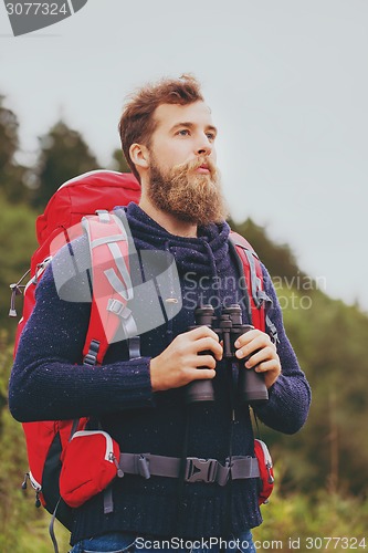 Image of man with backpack and binocular outdoors