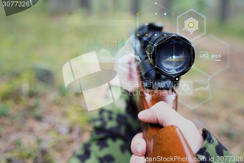 Image of close up of soldier or sniper with gun in forest