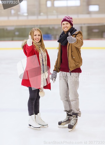 Image of happy couple holding hands on skating rink