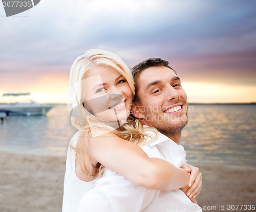 Image of couple having fun and hugging on beach