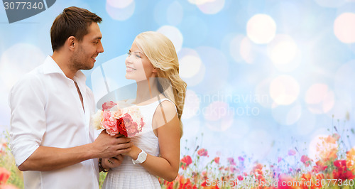 Image of happy couple with flowers over lights background