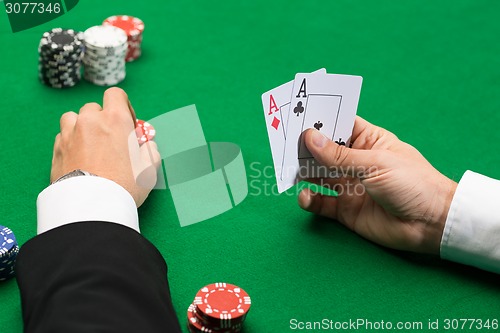 Image of poker player with cards and chips at casino