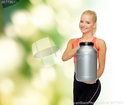 Image of smiling sporty woman with jar of protein