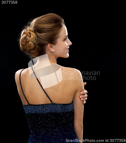 Image of smiling woman in evening dress from the back