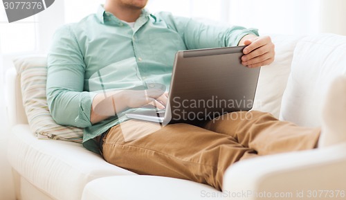 Image of close up of man working with laptop at home