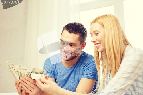 Image of couple with money at home