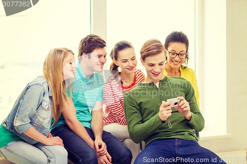 Image of smiling students with digital camera at school