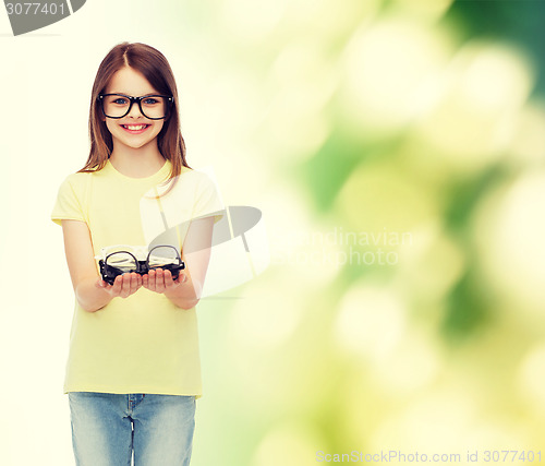 Image of smiling cute little girl in black eyeglasses