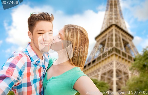 Image of happy couple taking selfie over eiffel tower