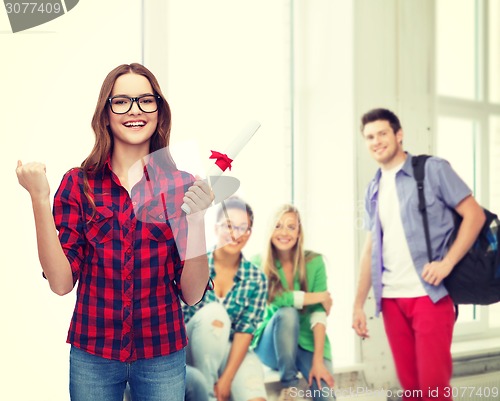 Image of smiling female student in eyeglasses with diploma