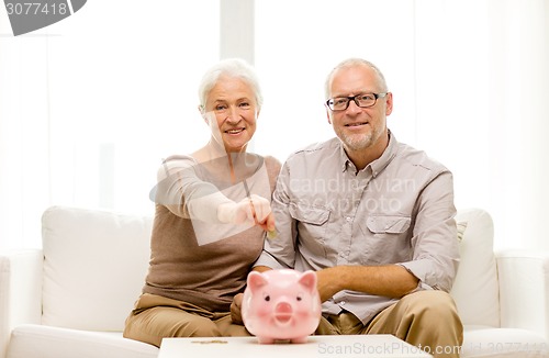 Image of senior couple with money and piggy bank at home