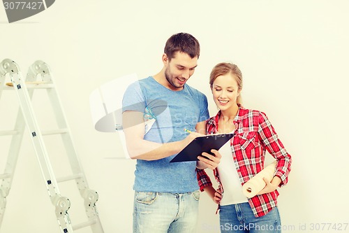 Image of smiling couple with clipboard and wallpaper roll