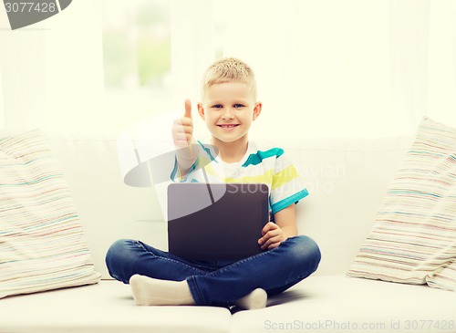 Image of smiling boy with tablet computer at home