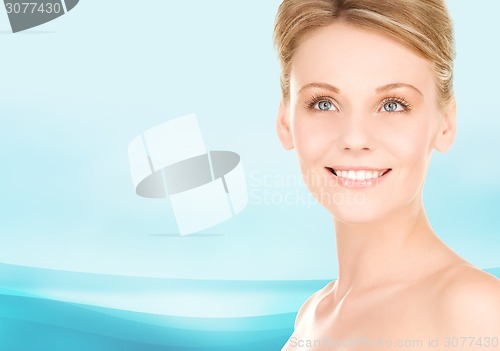 Image of close up of smiling woman over blue background