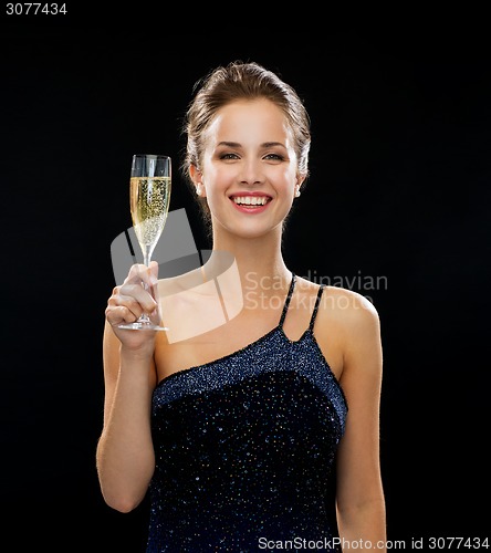 Image of smiling woman holding glass of sparkling wine