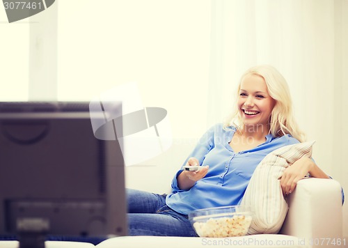 Image of young girl with popcorn watching movie at home