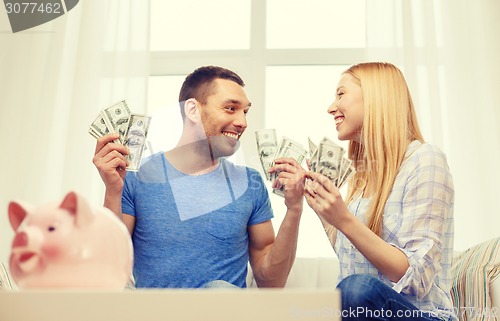 Image of couple with money and piggybank ot table at home