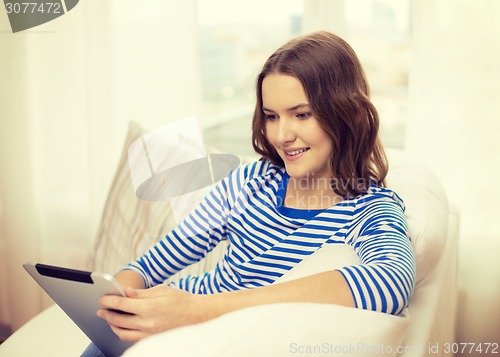 Image of smiling teenage girl with tablet pc at home