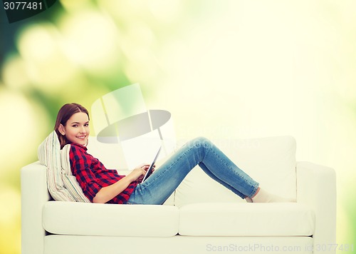 Image of teenage girl sitting on sofa with tablet pc