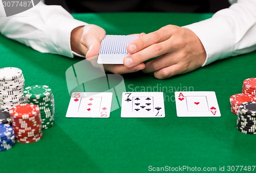 Image of holdem dealer with playing cards and casino chips