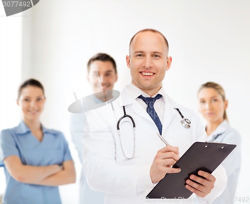 Image of smiling male doctor with clipboard and stethoscope