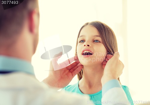 Image of male doctor checks little girl lymph nodes