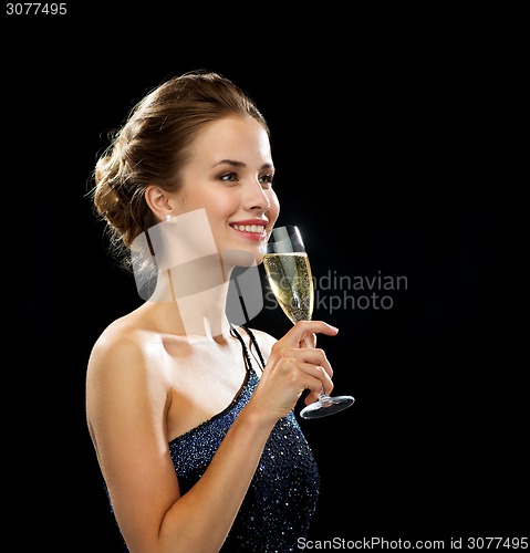 Image of smiling woman holding glass of sparkling wine
