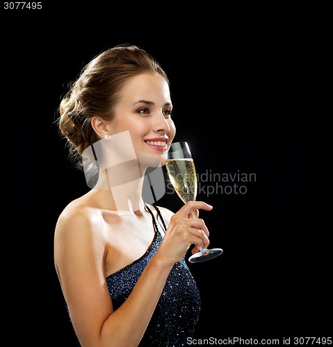 Image of smiling woman holding glass of sparkling wine